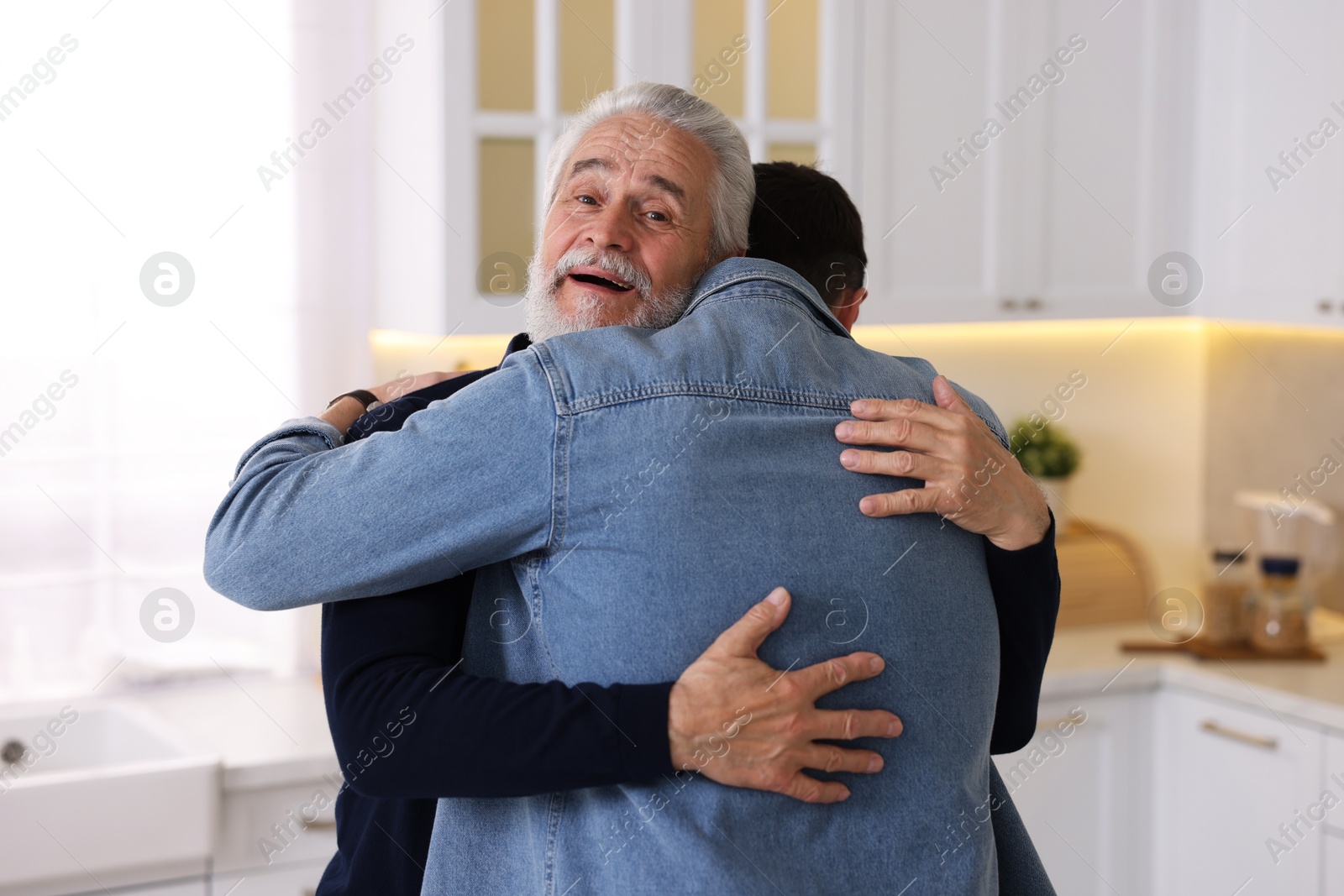 Photo of Happy dad and his son hugging at home