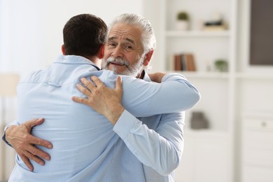 Happy dad and his son hugging at home