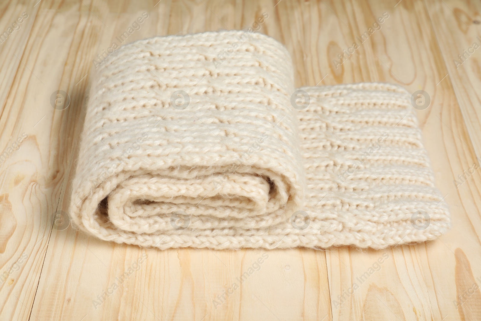 Photo of One knitted scarf on wooden table, closeup