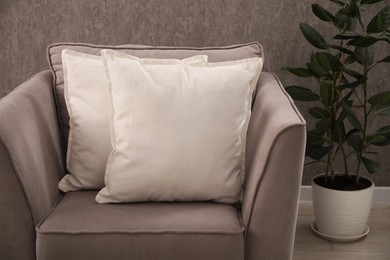 Photo of Soft pillows on grey armchair in room