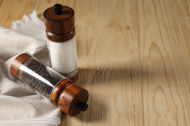 Salt and pepper shakers on wooden table. Space for text