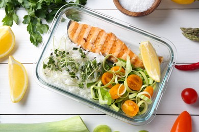 Healthy meal. Salmon, rice and salad in container near other products on white wooden table, flat lay