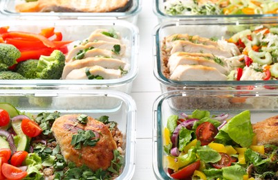 Photo of Healthy meal. Containers with different products on white wooden table