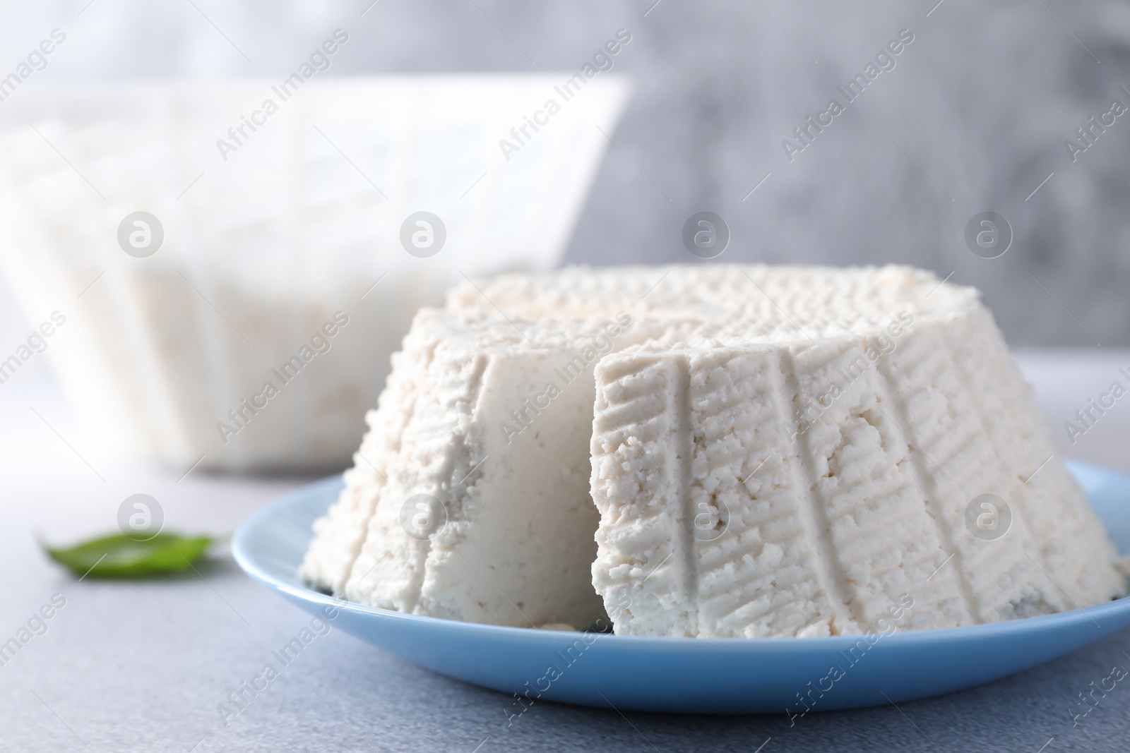 Photo of Tasty ricotta (cream cheese) on grey table, closeup