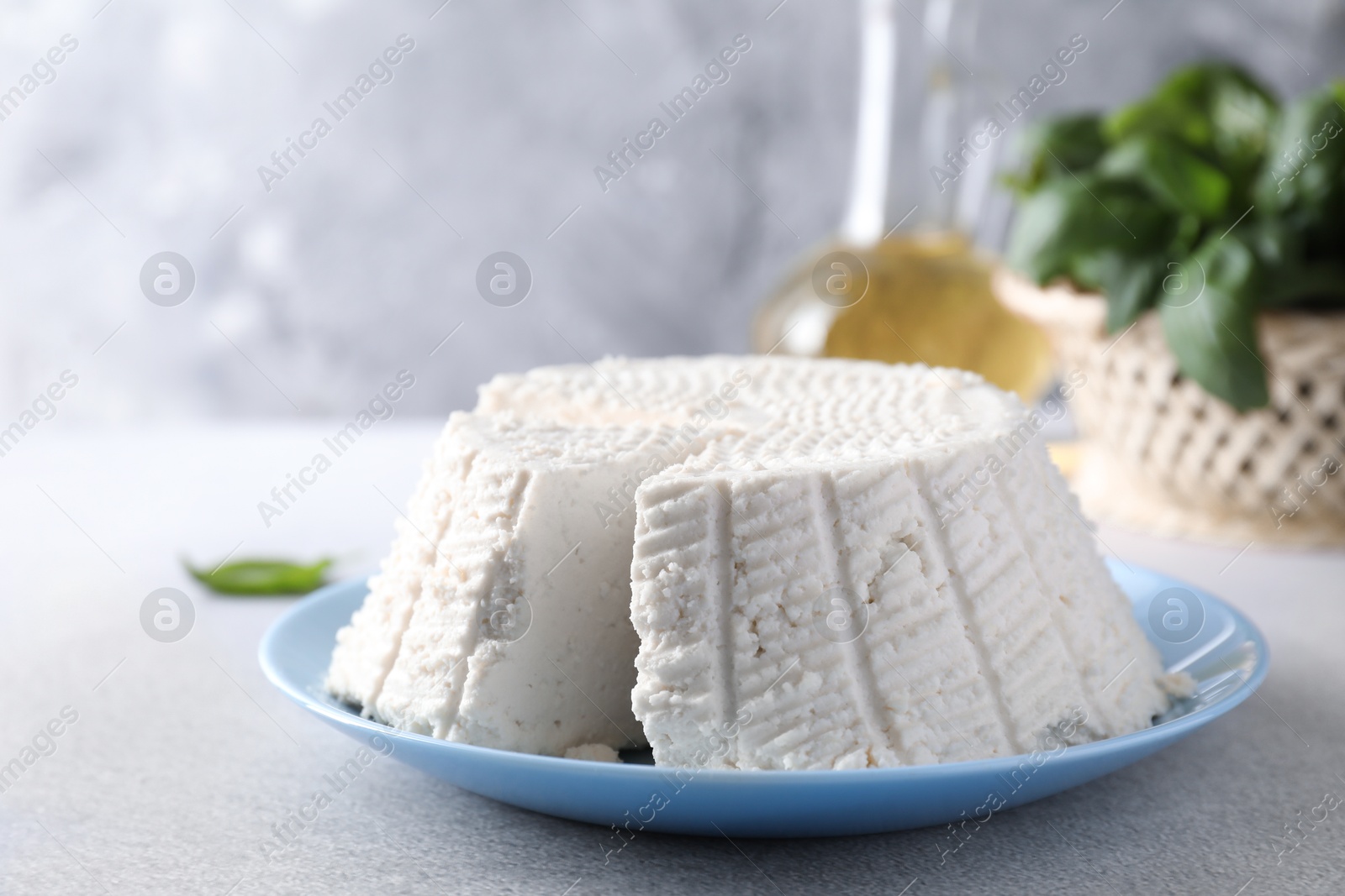 Photo of Tasty ricotta (cream cheese) on grey table, closeup