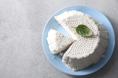 Tasty ricotta (cream cheese) on grey table, top view. Space for text