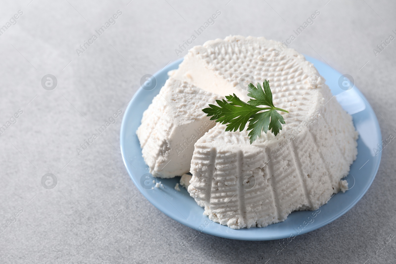 Photo of Tasty ricotta (cream cheese) on grey table, space for text