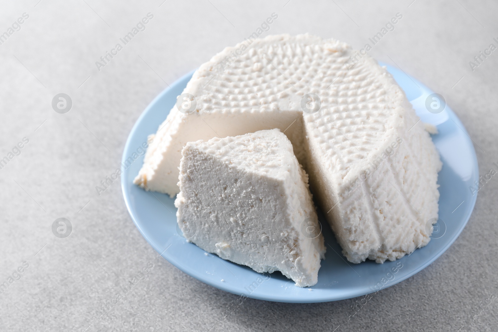 Photo of Tasty ricotta (cream cheese) on grey table