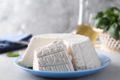 Photo of Tasty ricotta (cream cheese) on grey table, closeup