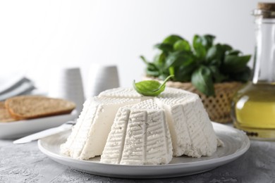 Tasty ricotta (cream cheese) and knife on grey textured table, closeup