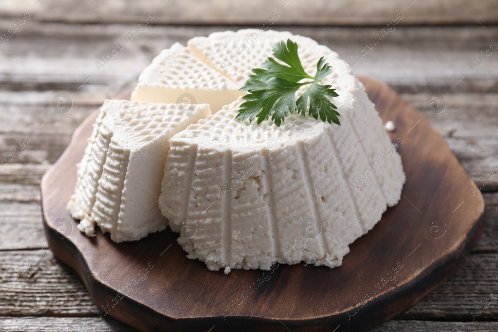 Photo of Tasty ricotta (cream cheese) on wooden table, closeup