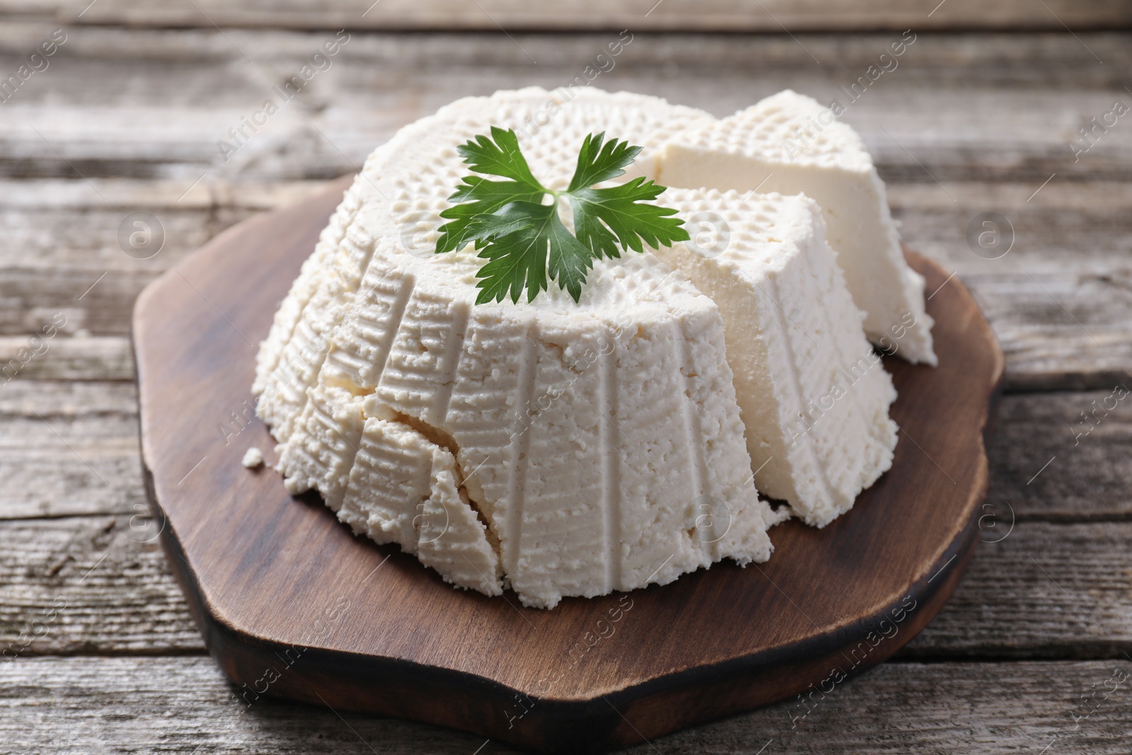 Photo of Tasty ricotta (cream cheese) on wooden table, closeup