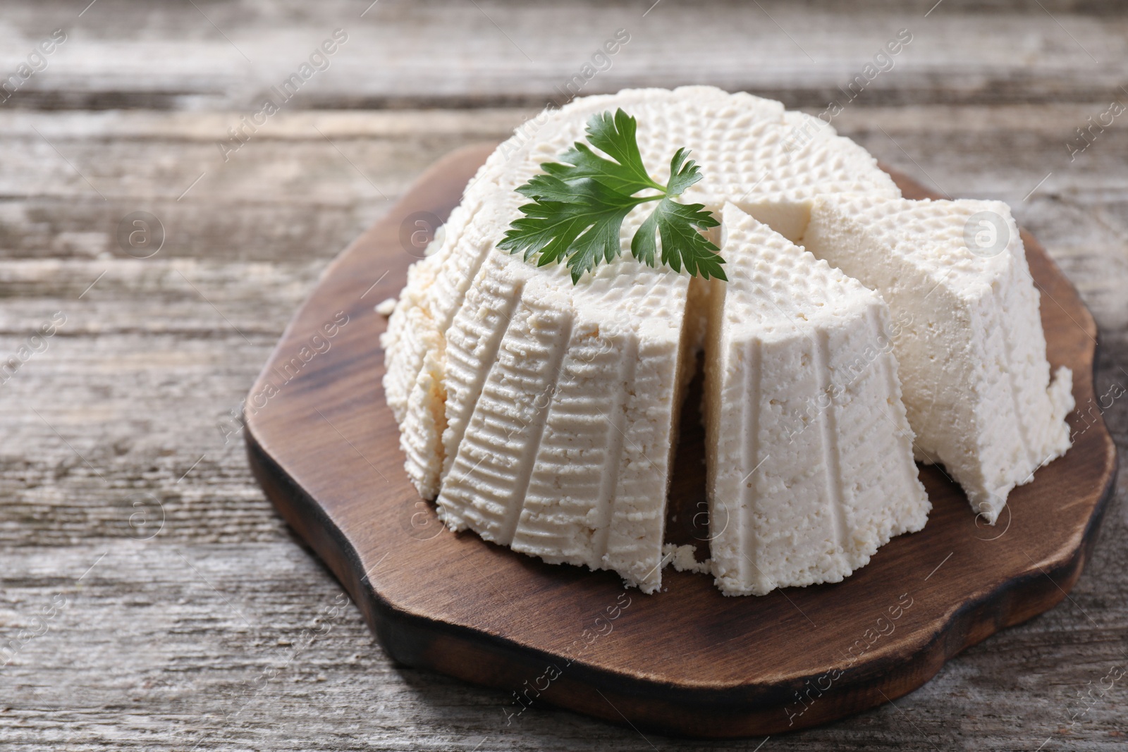 Photo of Tasty ricotta (cream cheese) on wooden table, closeup