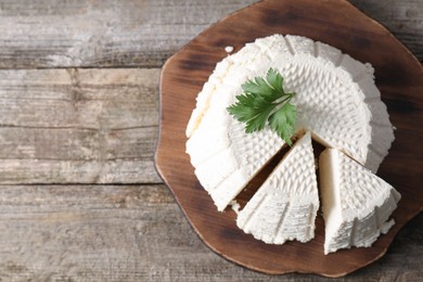 Tasty ricotta (cream cheese) on wooden table, top view. Space for text