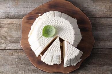 Tasty ricotta (cream cheese) on wooden table, top view