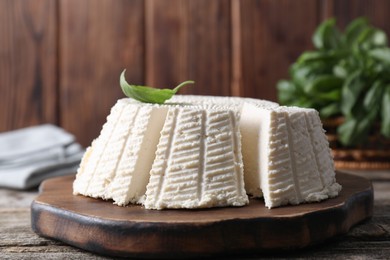 Photo of Tasty ricotta (cream cheese) on wooden table, closeup
