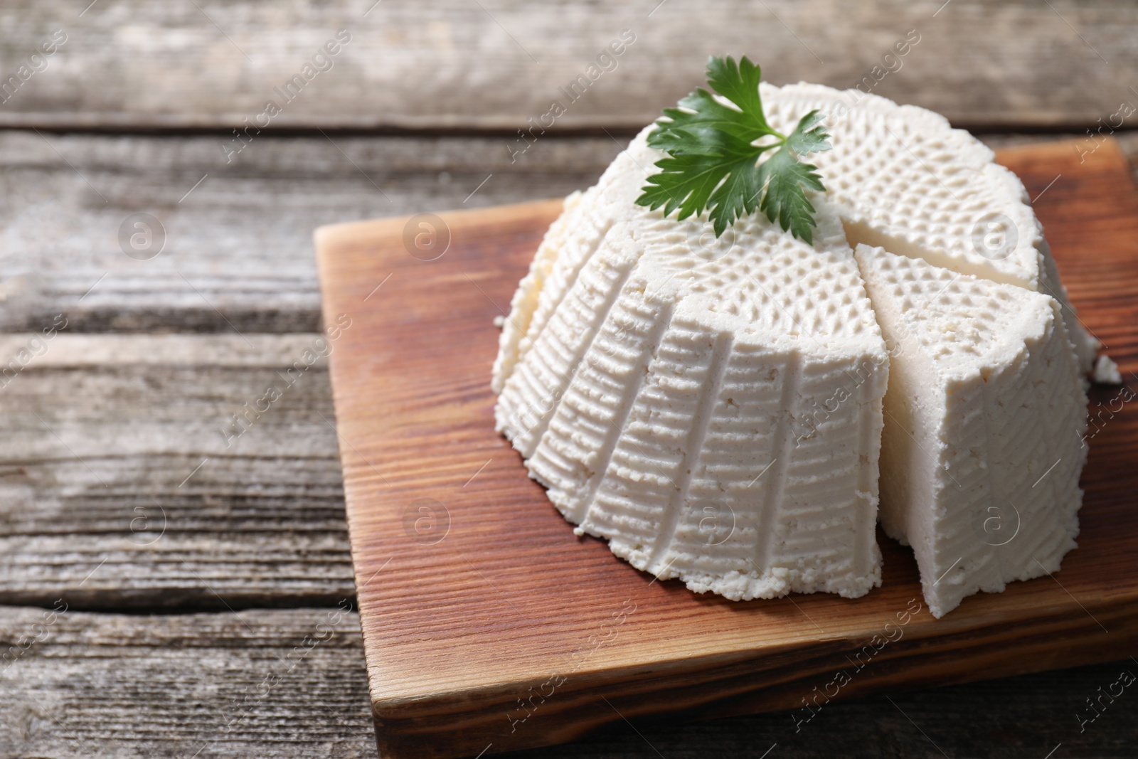 Photo of Tasty ricotta (cream cheese) on wooden table. Space for text