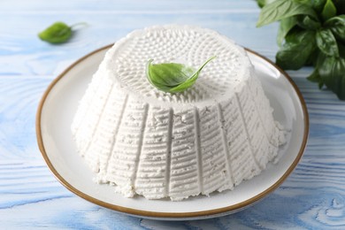 Tasty ricotta (cream cheese) on light blue wooden table