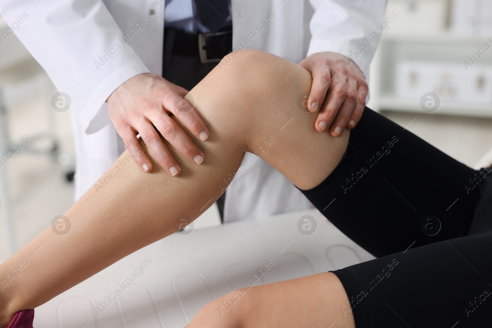 Photo of Sports injury. Doctor examining patient's leg in hospital, closeup