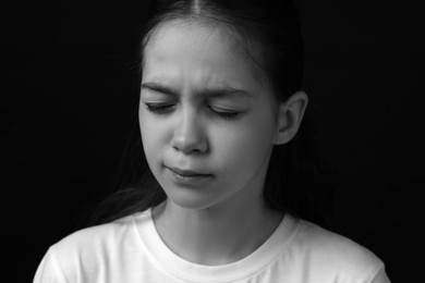 Portrait of sad girl in darkness, closeup. Black and white effect