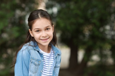 Portrait of happy little girl outdoors, space for text