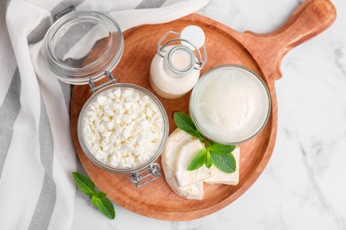 Photo of Different dairy products and mint on white marble table, top view