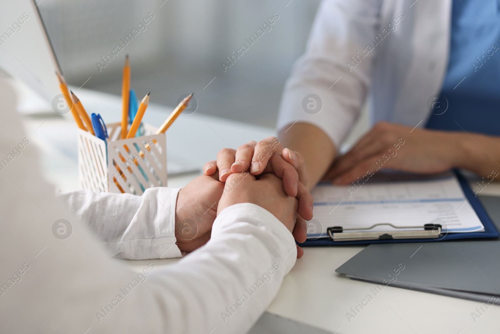 Photo of Professional doctor working with patient at white table in hospital, closeup