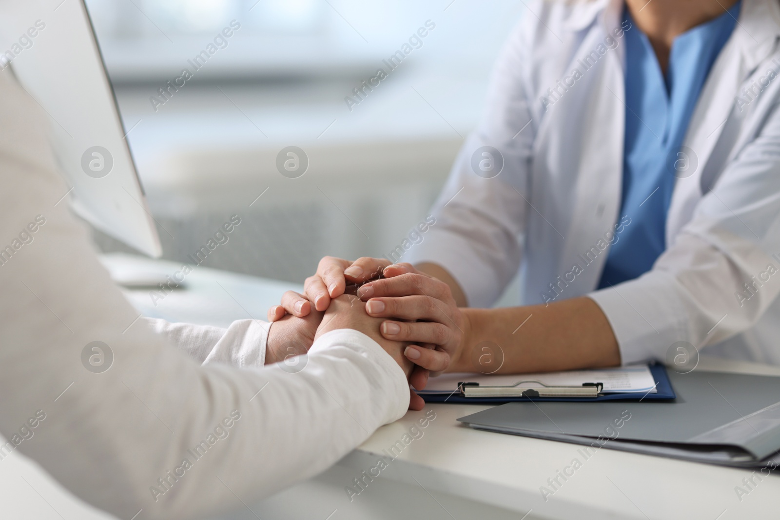 Photo of Professional doctor working with patient at white table in hospital, closeup