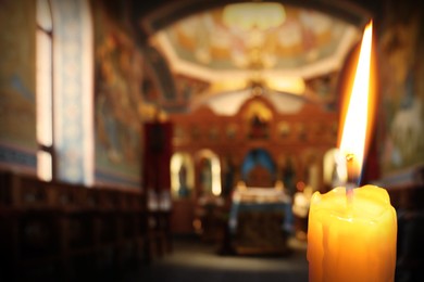 Image of Church candle burning in temple, closeup. Space for text