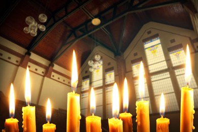 Image of Many church candles burning in temple, closeup