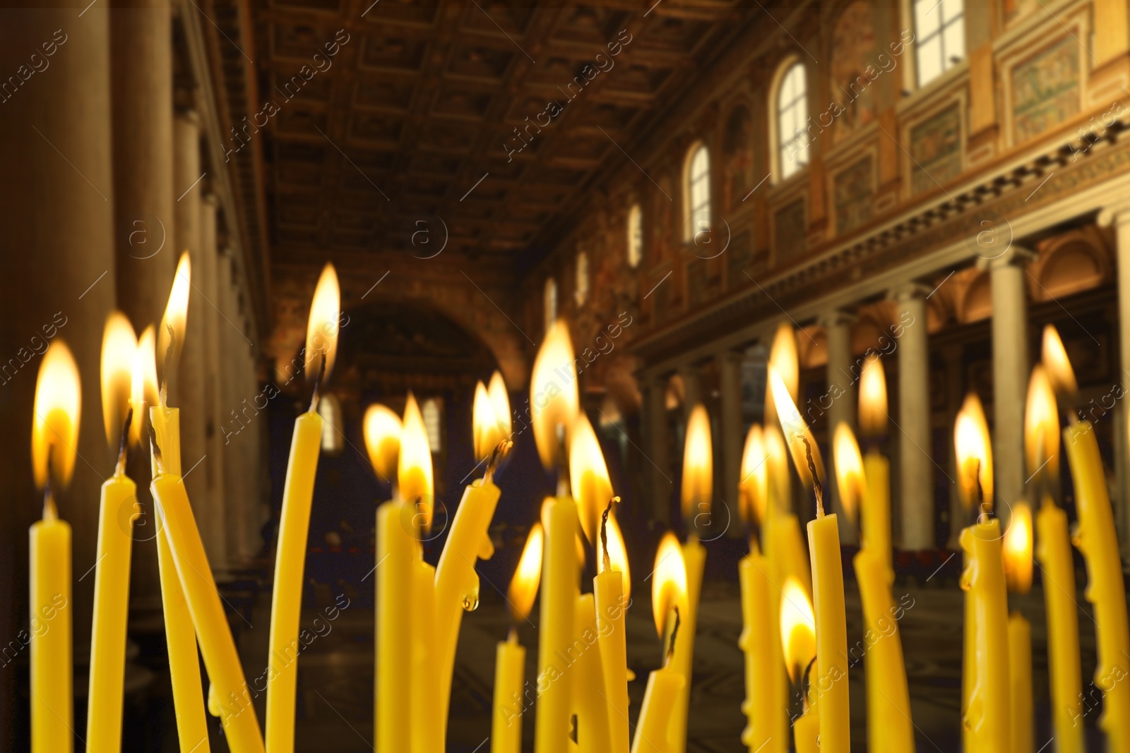 Image of Many church candles burning in temple, closeup