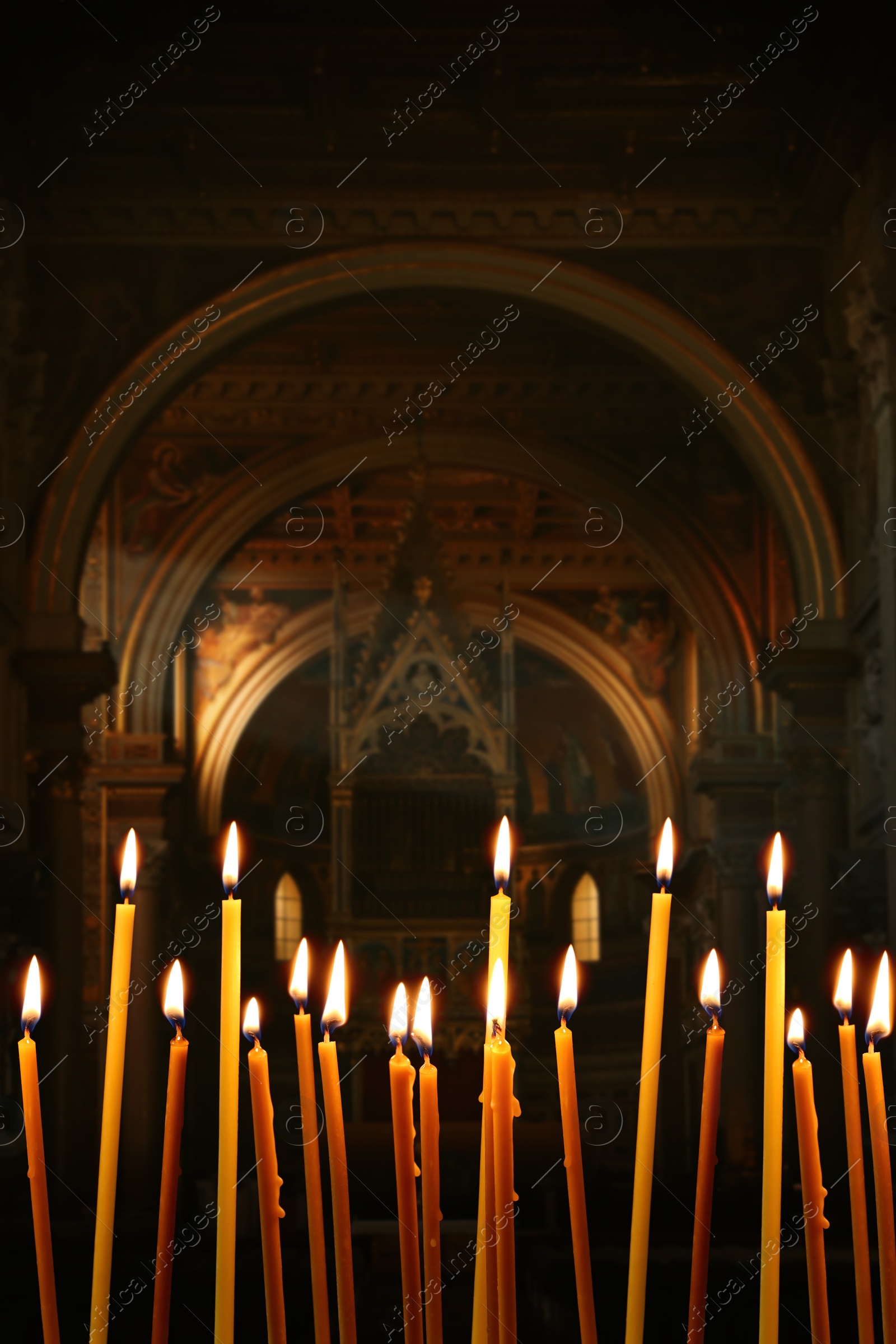 Image of Many church candles burning in temple, closeup