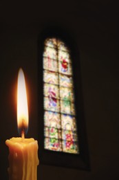 Church candle burning in temple, closeup. Space for text