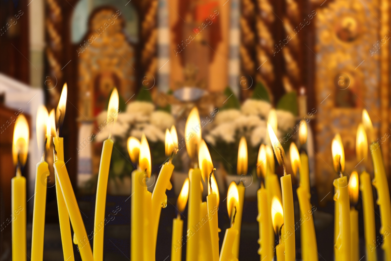 Image of Many church candles burning in temple, closeup