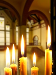 Many church candles burning in temple, closeup