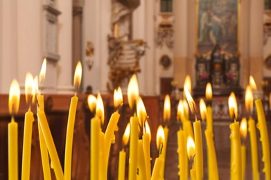 Image of Many church candles burning in temple, closeup