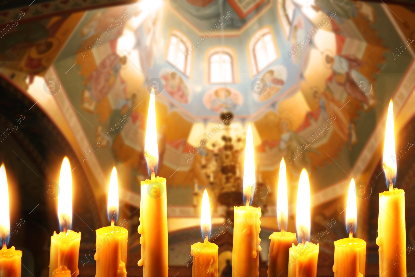 Image of Many church candles burning in temple, closeup