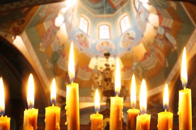 Image of Many church candles burning in temple, closeup