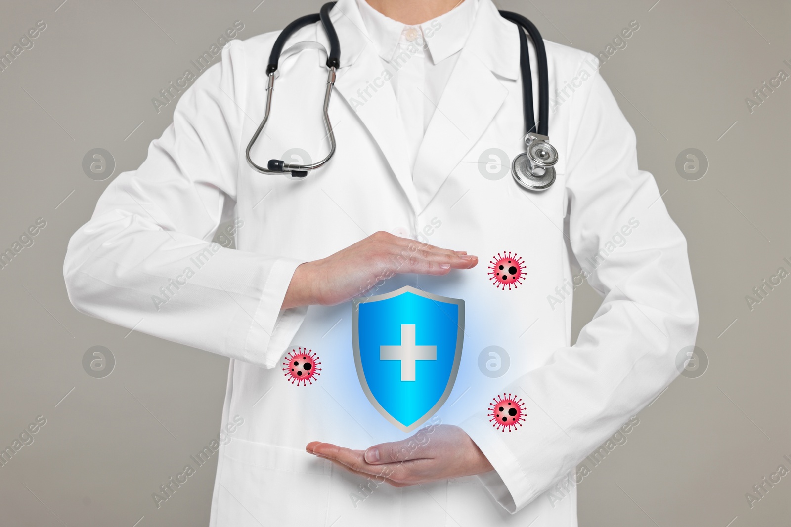 Image of Strong immunity blocking viruses. Doctor holding illustration of shield on grey background, closeup