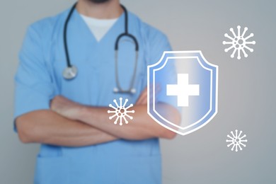 Strong immunity, concept. Doctor and illustration of shield and viruses on grey background
