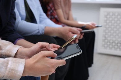 People holding smartphones with blank screens indoors, closeup