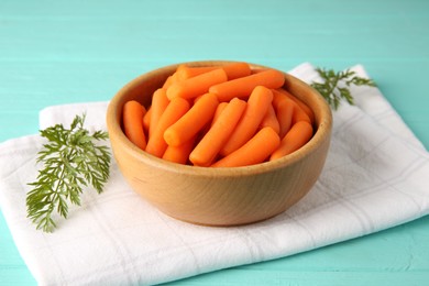 Photo of Baby carrots and green leaves on light blue wooden table