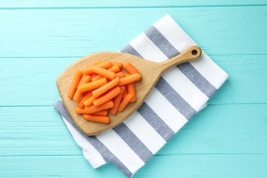 Baby carrots on light blue wooden table, top view