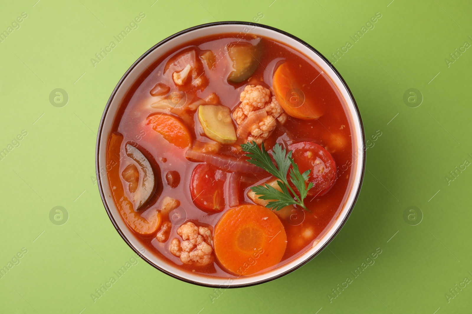 Photo of Tasty homemade stew with vegetables on light green table, top view