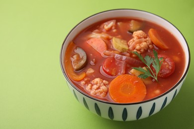 Tasty homemade stew with vegetables on light green table, closeup. Space for text