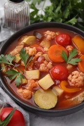 Tasty homemade stew with vegetables on white marble table, closeup