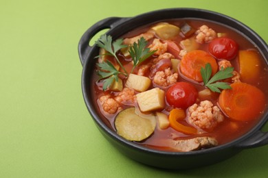 Tasty homemade stew with vegetables on light green table, closeup. Space for text