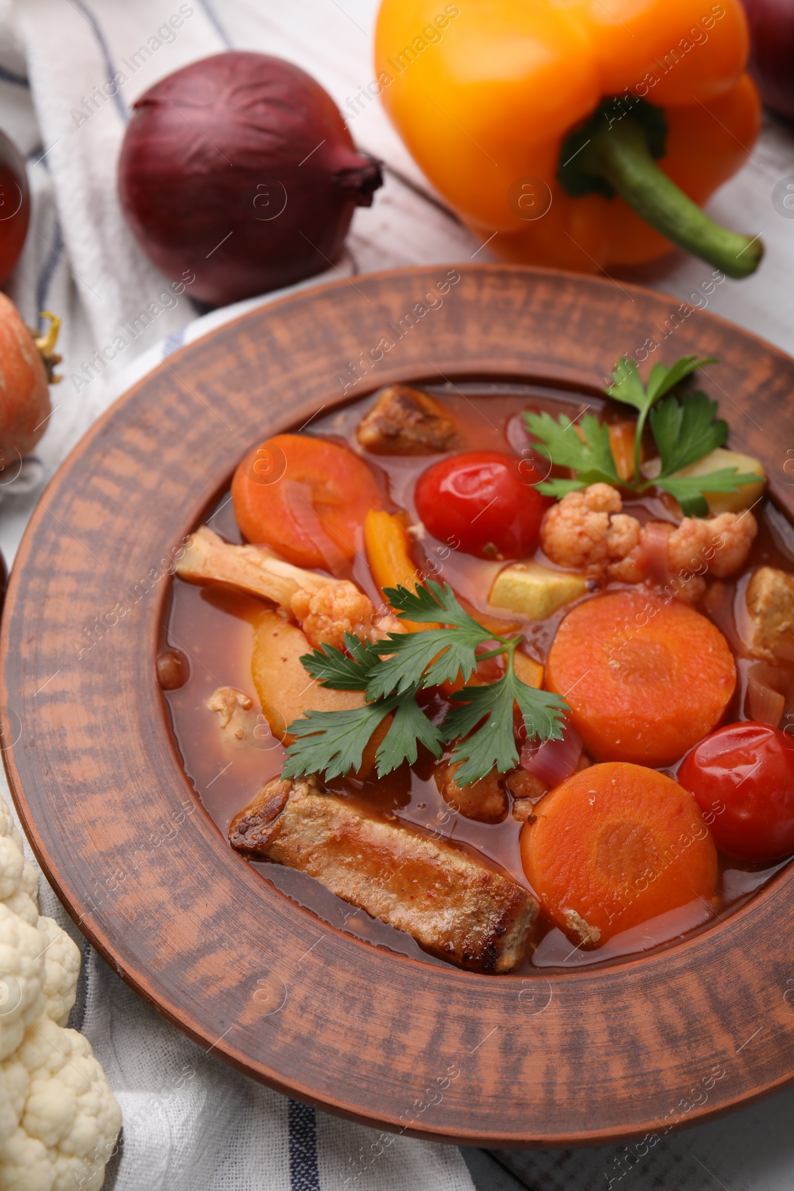 Photo of Tasty homemade stew with vegetables on white wooden table, closeup