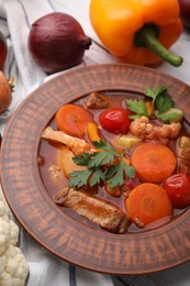 Tasty homemade stew with vegetables on white wooden table, closeup