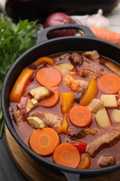 Tasty homemade stew with vegetables on grey wooden table, closeup